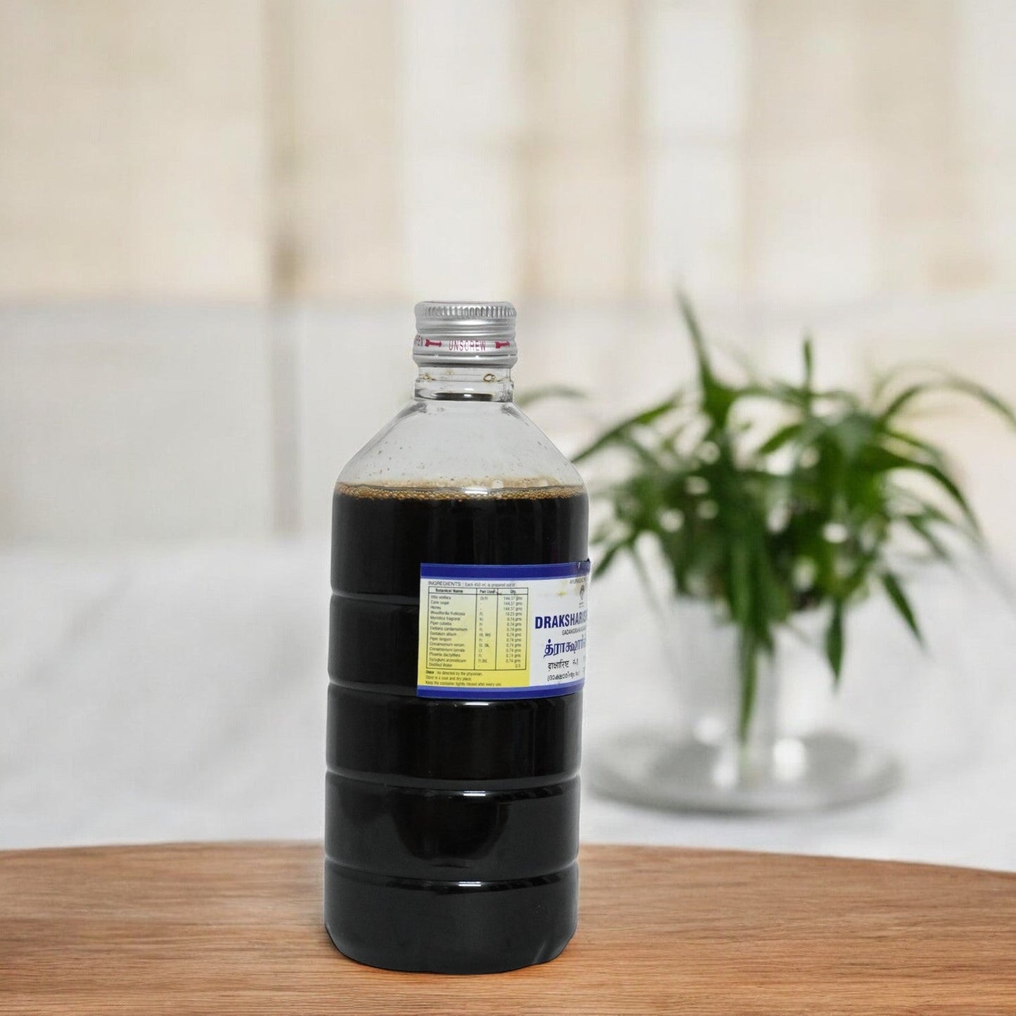 Impocops Draksharishta No.I Ayurvedic herbal tonic in a glass bottle, with a dark liquid and label visible.