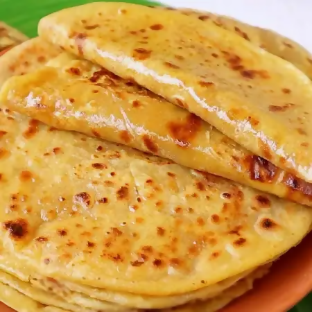 Gummadi Foods Bobbatlu (Belam), North Indian sweet with stuffed filling, golden-brown flatbread on a plate.
