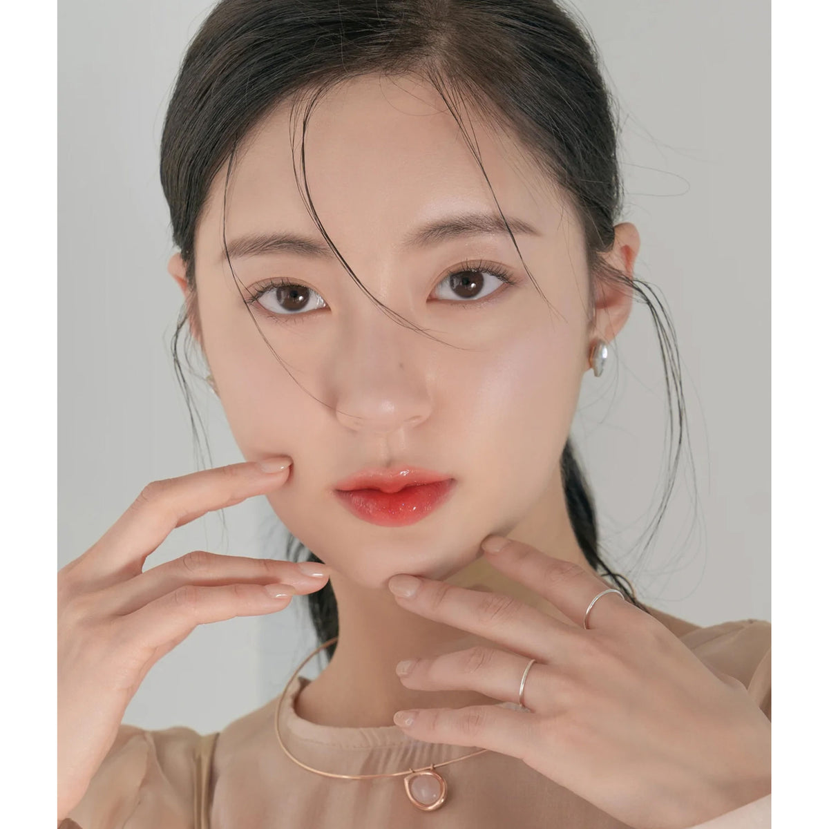 Rom&nd Glasting Water Tint in Coral Mist, featuring a vibrant coral-colored lip tint with a glossy finish.