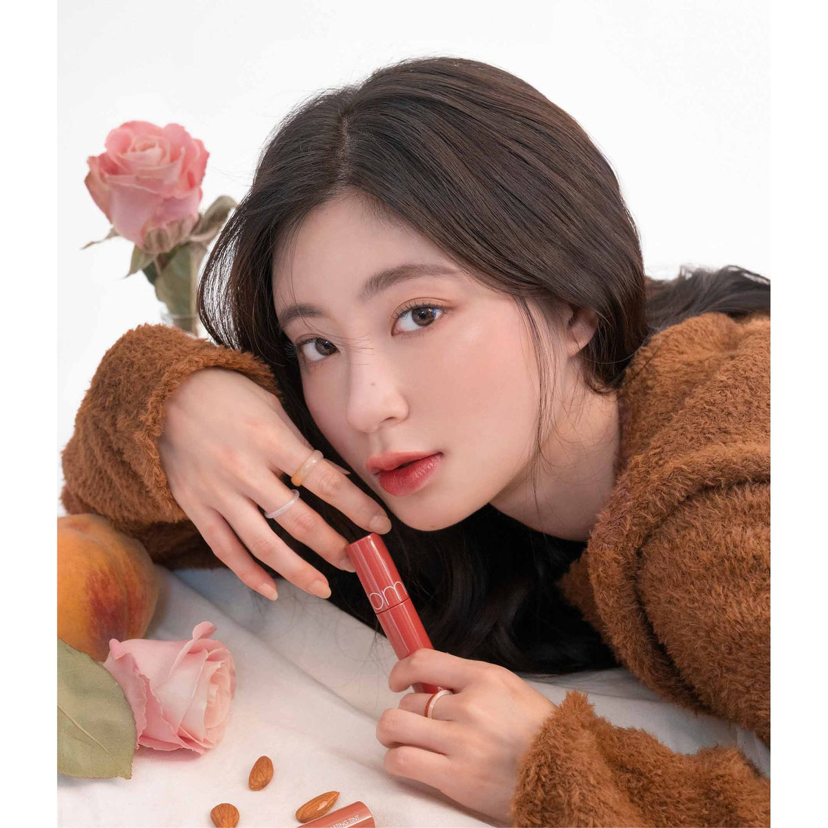 Rom&nd The Juicy Lasting Tint in 18 Mulled Peach, showing the peach-colored lip tint tube with its vibrant packaging.