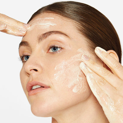 Dermalogica Daily Milkfoliant vegan oat-based powder exfoliant shown in a white jar with a scoop, designed for gentle skin renewal.