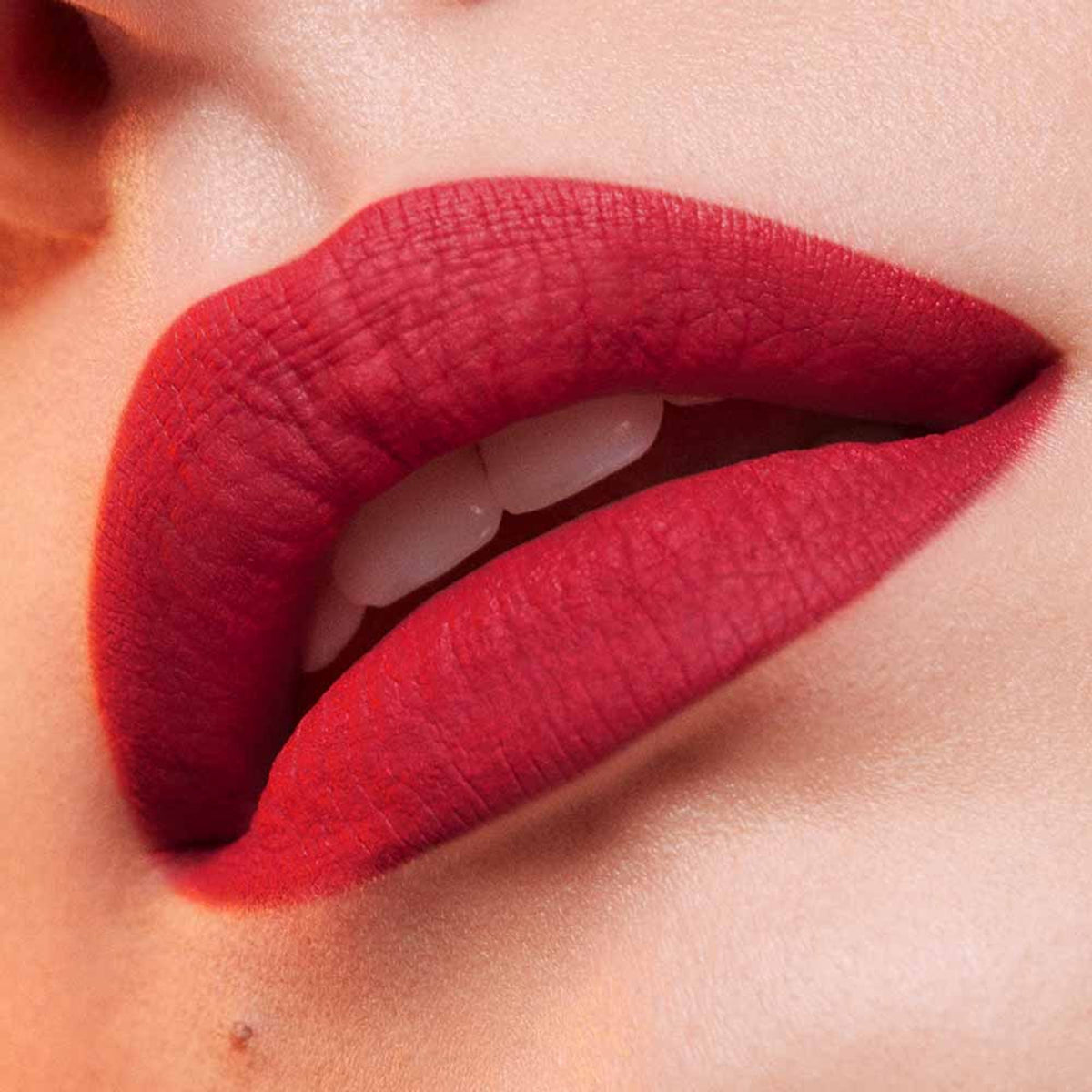 Estee Lauder Pure Color Whipped Matte Lip Color in Maraschino, showing a vibrant red lipstick in a sleek tube.