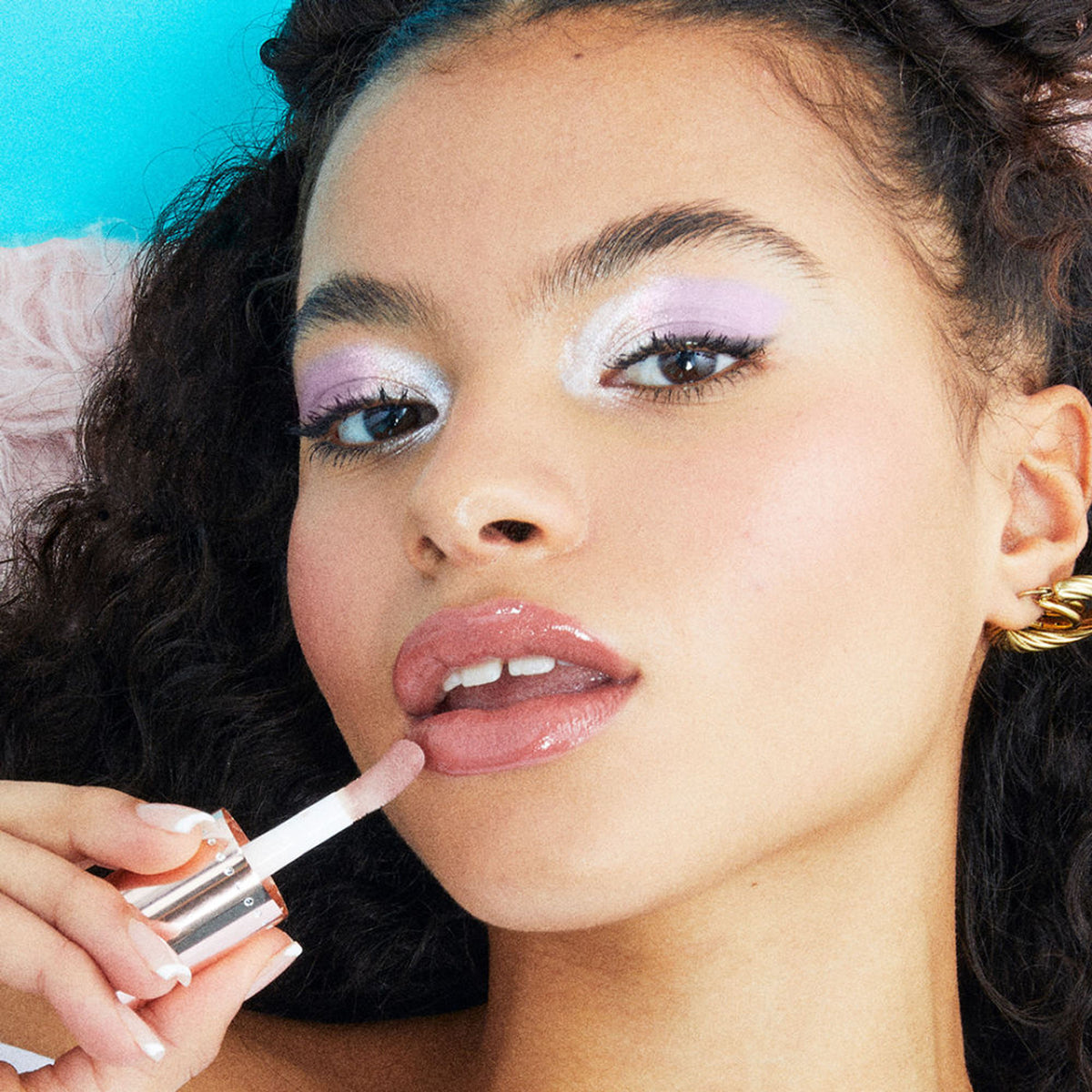 Makeup Revolution Y2K Baby Sweet Bomb Lip Gloss in Strawberry Swirl Nude, featuring a shiny, smooth lip gloss with a pink and nude tint.