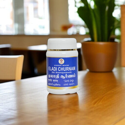 Impcops Eladi Churnam Ayurvedic herbal powder in a traditional container, showcasing its fine, aromatic dried cardamom spice.