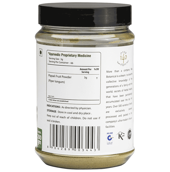 Bixa Botanical Pippali Powder in a clear glass jar, showcasing fine reddish-brown Ayurvedic powder on a wooden surface.