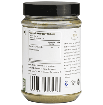 Bixa Botanical Pippali Powder in a clear glass jar, showcasing fine reddish-brown Ayurvedic powder on a wooden surface.