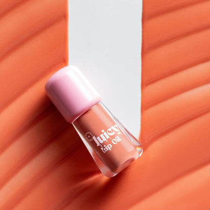 Gush Beauty Balmy Glossy Tinted Lip Oil in Soft Peach, showing a clear tube with peach-colored lip gloss inside.