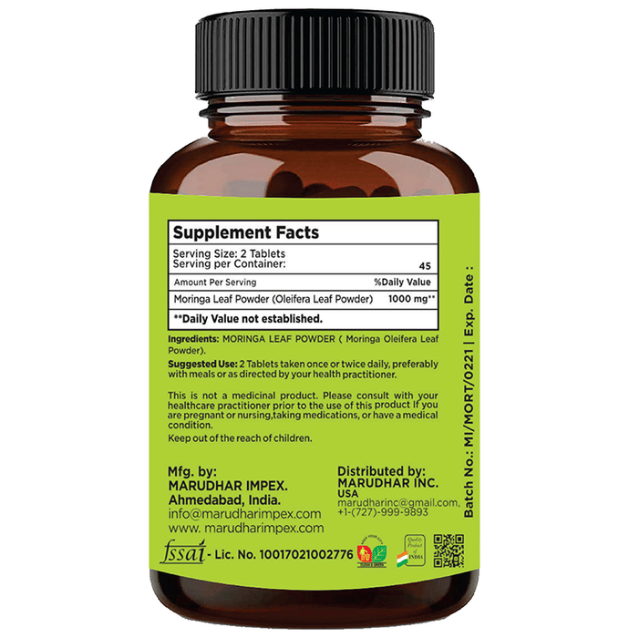 Minature Ayurvedic Moringa Leaf Tablets, 100% natural mini tablets, shown in blister pack with green Moringa leaves.