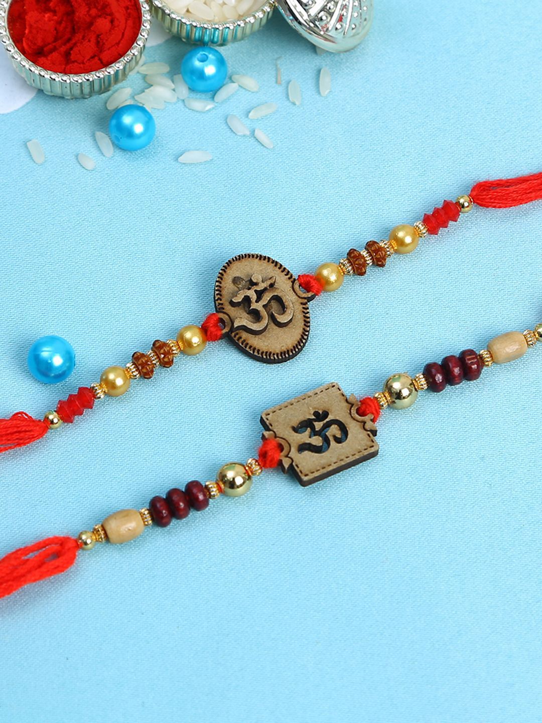 Anouk Set Of 2 Red Wooden Om Beaded Rakhi With Roli Rice & Greeting Card