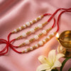 Dhiyona Set Of 4 White Pearls & Red Thread Rakhi With Roli Chawal Chandan Mishri