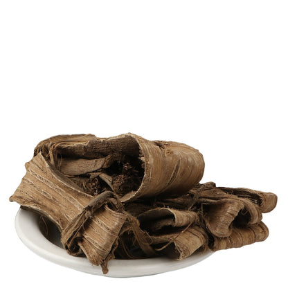 Yuvika Dandasa walnut tree peel, Ayurvedic product in a clear glass jar with dried walnut peel pieces inside.