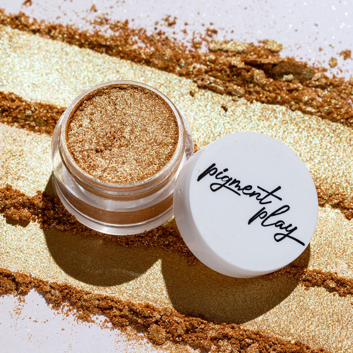 Iridescent loose powder by Pigment Play in Lucky Green with shimmering, vibrant green pigment in a loose makeup container