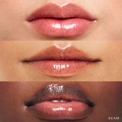 Rare Beauty Positive Light Luminizing Lip Gloss in Beam, clear tube showing glossy, shimmering lip gloss with subtle shine and branding.