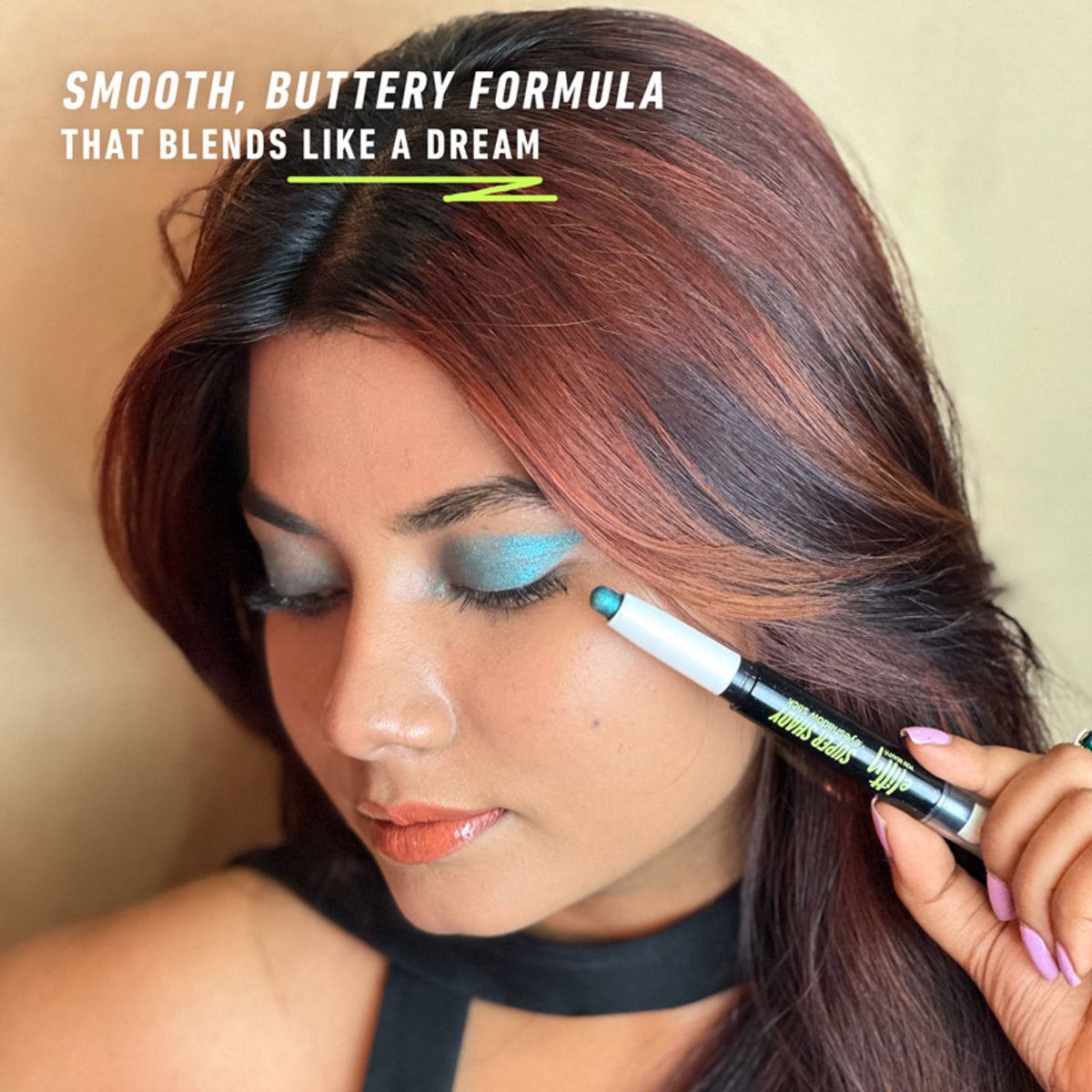 Elitty Eyeshadow Stick in Blue Lagoon with vibrant blue and teal shades, smoothly applied on a cosmetic palette.