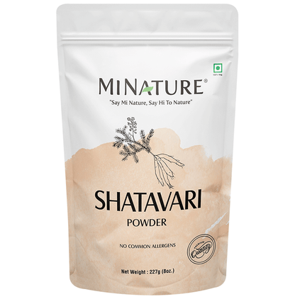 Organic Minature Shatavari powder in a glass jar, Ayurvedic herbal supplement for women, with fresh dried roots visible.