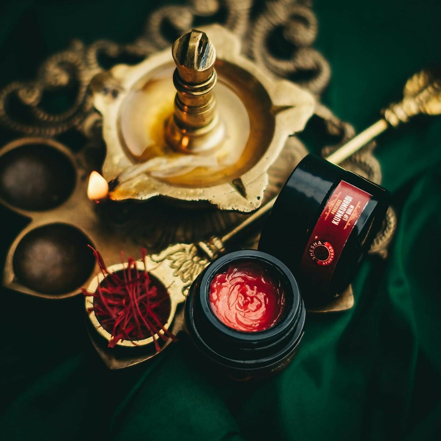 Shesha Ayurveda Kumkumadi Brightening Lip Balm in a small jar with a natural, herbal appearance and a smooth lip balm texture.