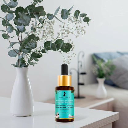 Pilgrim brightening face serum with 2% alpha arbutin and 3% vitamin C for glowing skin, in a clear glass bottle with dropper.