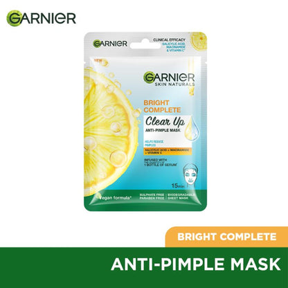 Garnier Bright Complete anti-pimple sheet mask with salicylic acid, niacinamide, and vitamin C serum applied to a face.