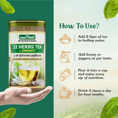 Jeena Sikho 32 Herbs Tea herbal detox Kahwa in a glass cup with dried herbs and tea leaves on a wooden table.