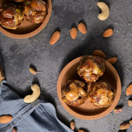 Vellanki Foods Dry Fruit Laddu showing golden brown dry fruit laddu with visible nuts and dried fruits on a white background.