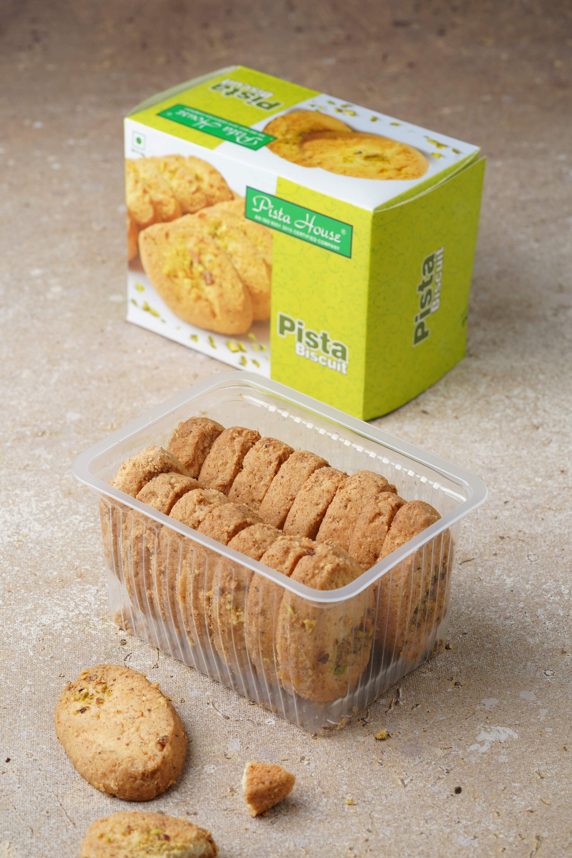 Pista House Pista Biscuits with green pistachio pieces on a white plate, showcasing the crunchy, nutty snack.