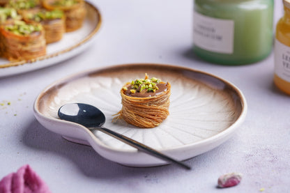 Gourmet Baklava Nutella Nest, North Indian sweet with layered flaky pastry and Nutella filling, served on a white plate.
