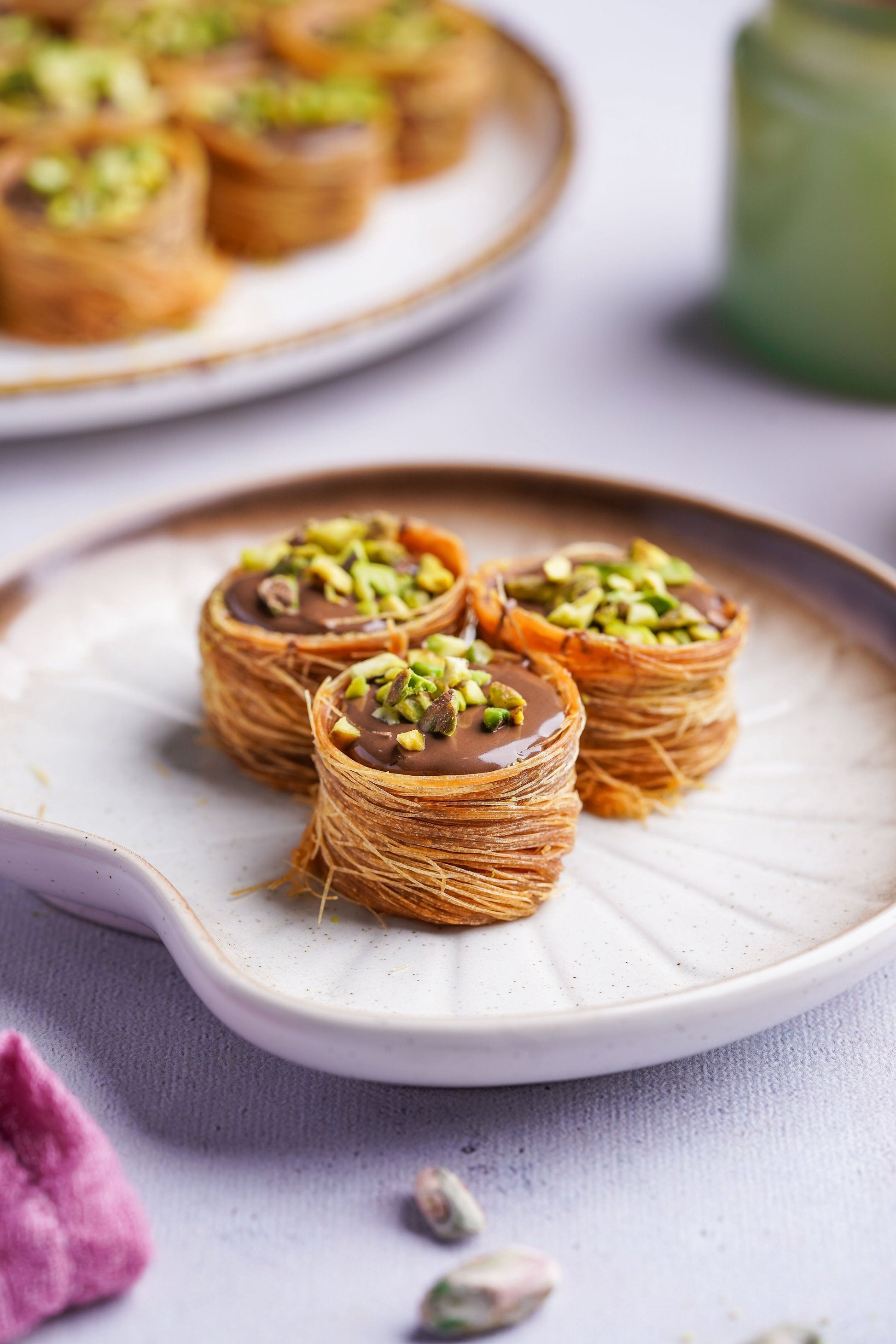 Gourmet Baklava Nutella Nest, North Indian sweet with layered pastry and Nutella filling, displayed on a white plate.