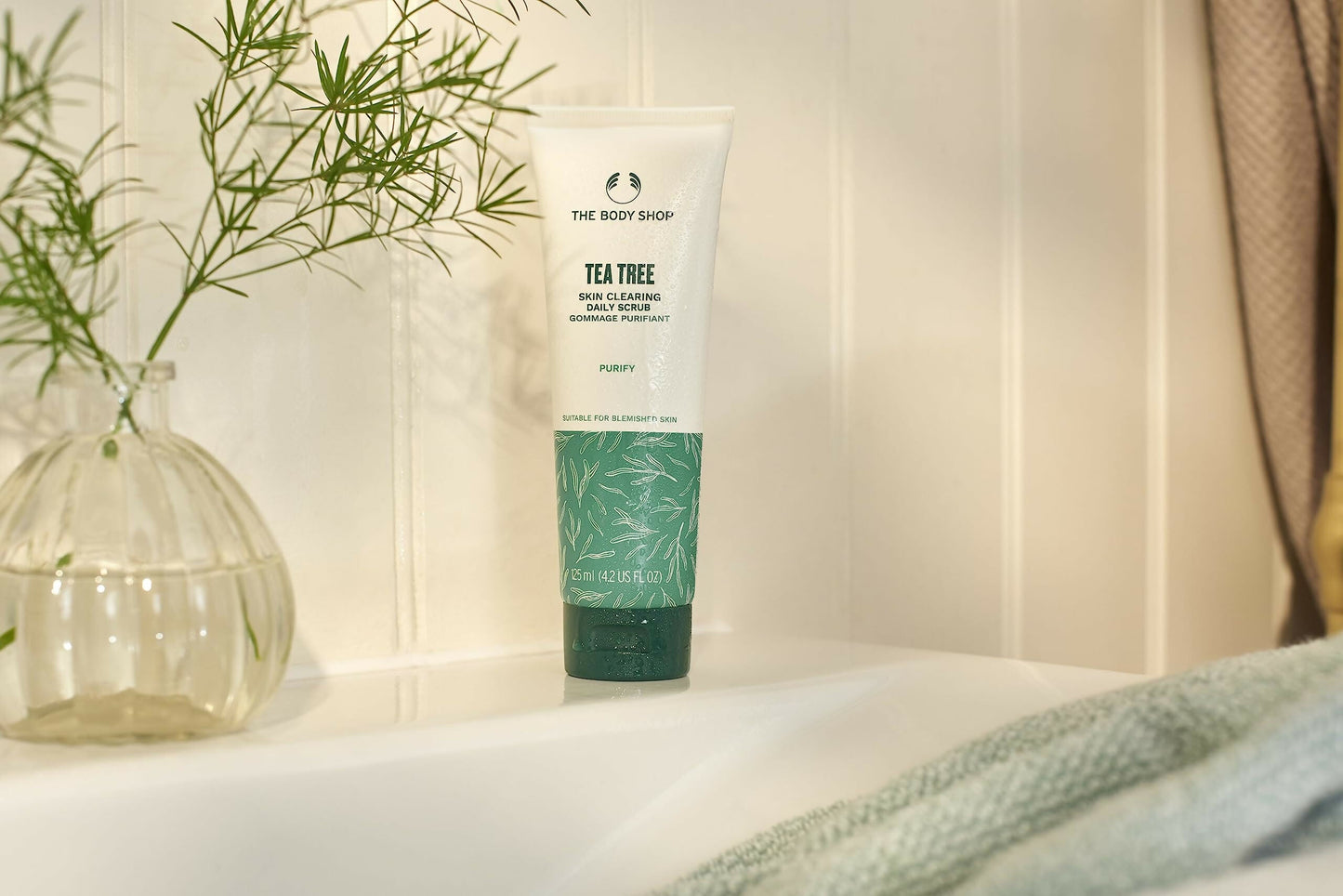The Body Shop Tea Tree Skin Clearing Daily Scrub with natural tea tree extract and exfoliating beads for refreshed skin.