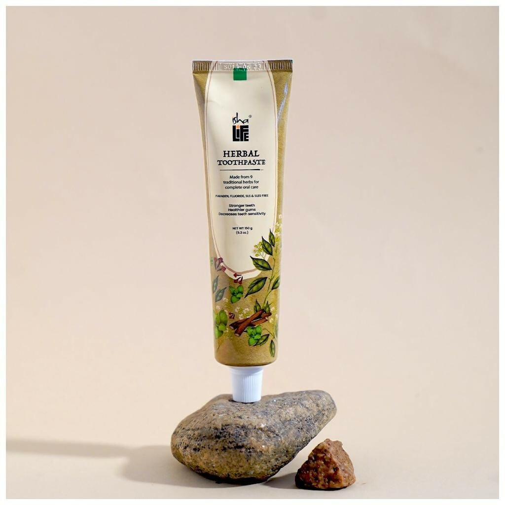 Isha Life herbal tooth powder and toothpaste combo in a natural, eco-friendly packaging with herbal ingredients visible.