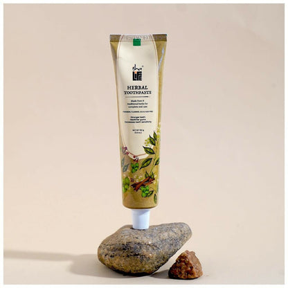 Isha Life herbal tooth powder and toothpaste combo in a natural, eco-friendly packaging with herbal ingredients visible.