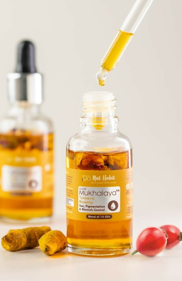Nat Habit Pure Turmeric Rosehip Mukhalaya Face Oil bottle showing golden-colored oil in a clear glass bottle with a white label.