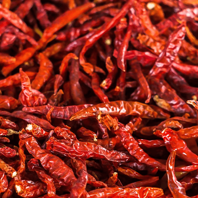 Asavi Stone Grounded Mathania Chilli Powder in a jar, vibrant red chili powder with a textured surface, ready for cooking.