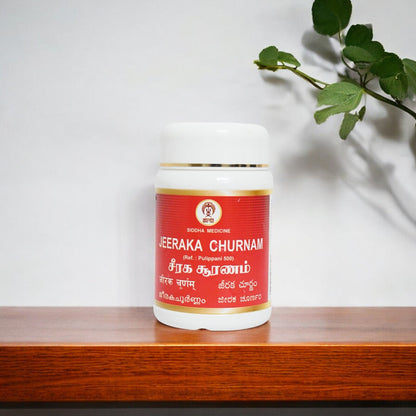 Impcops Jeeraka Churnam Ayurvedic herbal powder in a glass bowl with fresh cumin seeds on a white background.