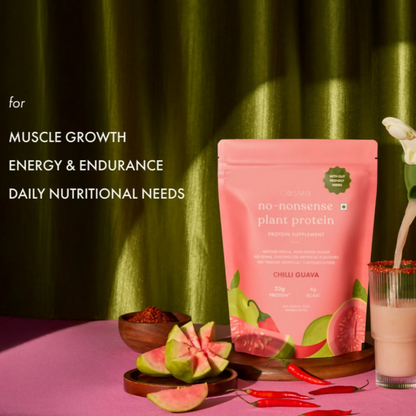 Cosmix No Nonsense Plant Protein Chilli Guava health drink in a glass with fresh guava and chili slices on the side.