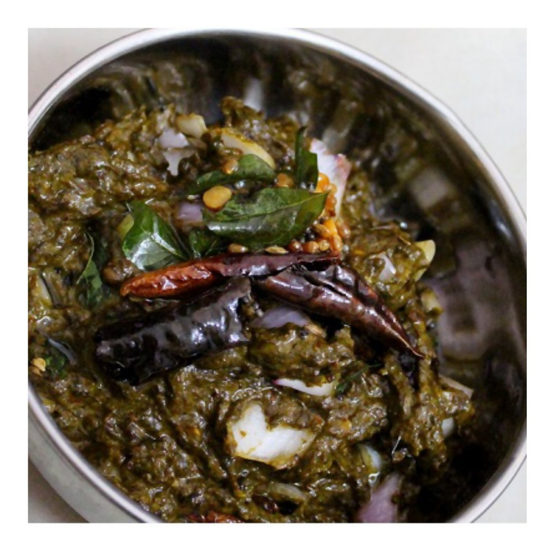 Jar of 21Pickles Gongura Pickle, North Indian-style pickle with vibrant green leaves and spices in a clear glass container.