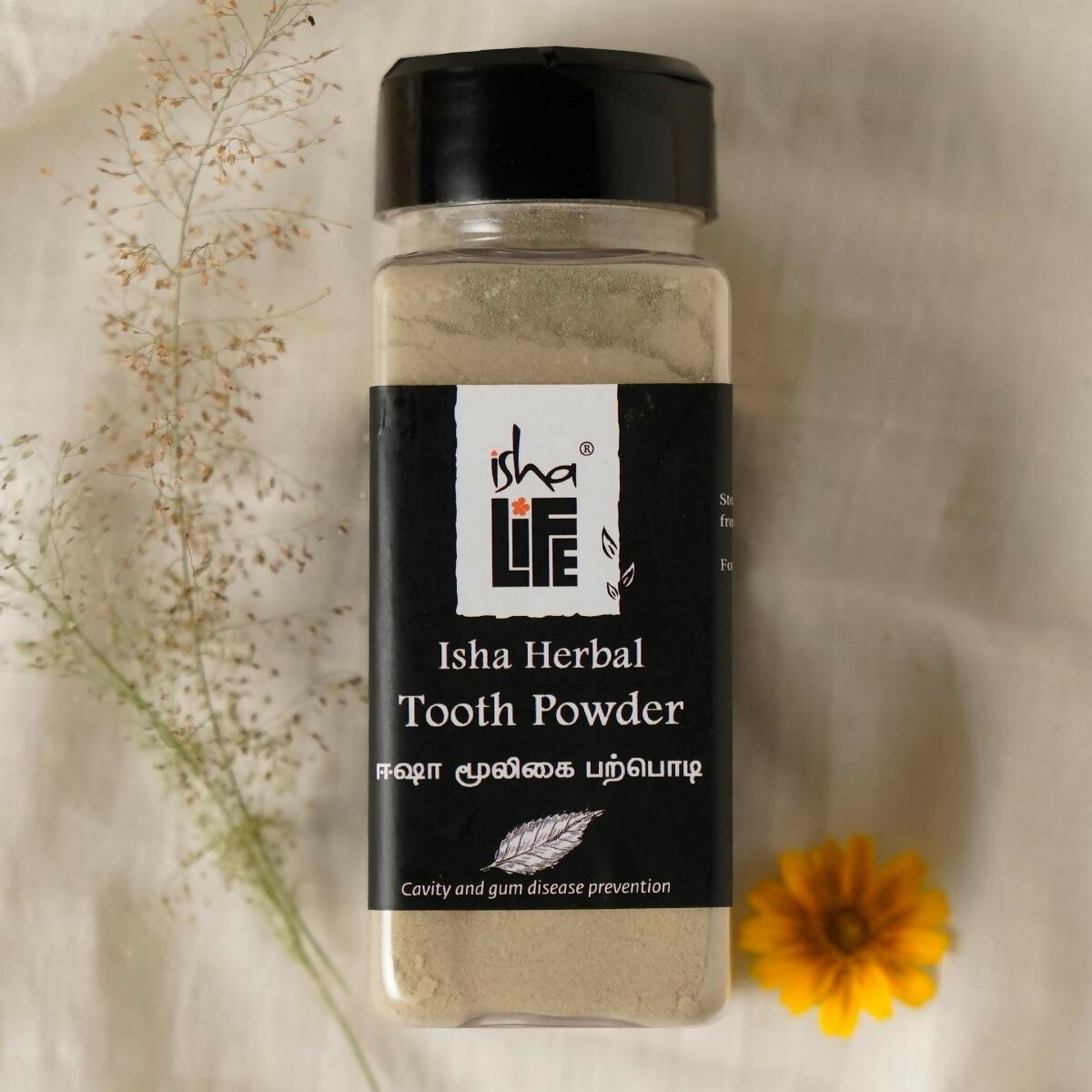 Isha Life herbal tooth powder and toothpaste combo in a natural packaging, showcasing traditional herbal dental care products.