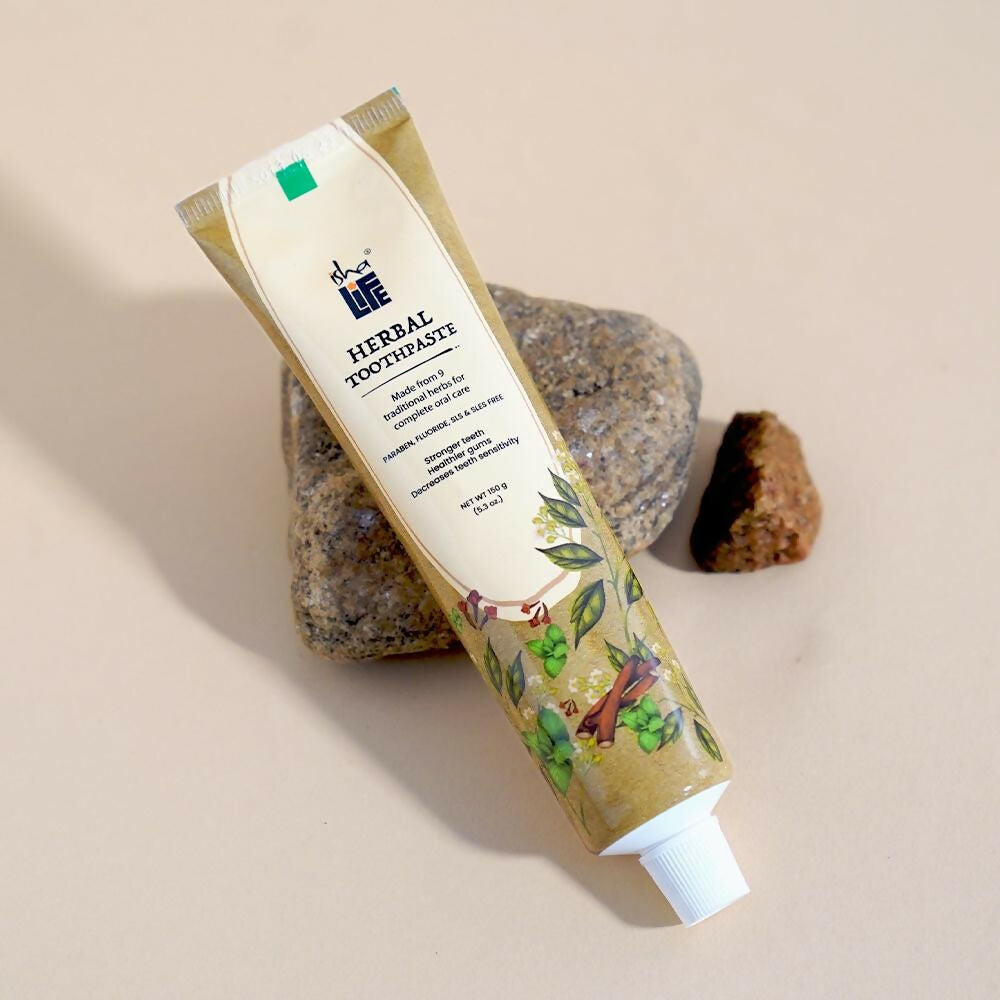 Isha Life herbal tooth powder in a natural container, showing its traditional packaging and herbal ingredients for oral care.