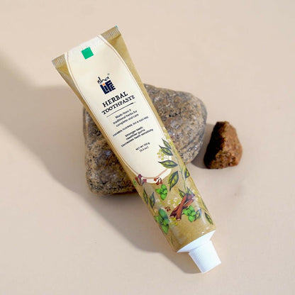 Isha Life herbal tooth powder in a natural container, showing its traditional packaging and herbal ingredients for oral care.