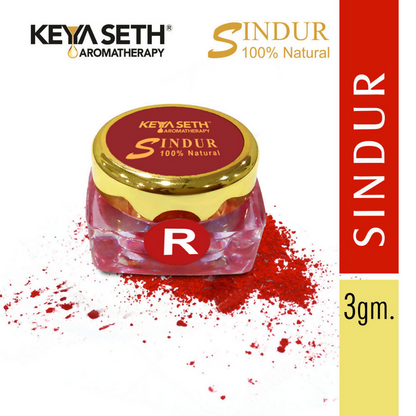 Red Sindoor powder in a natural makeup container from Keya Seth Aromatherapy, used for traditional Indian ceremonial adornment.