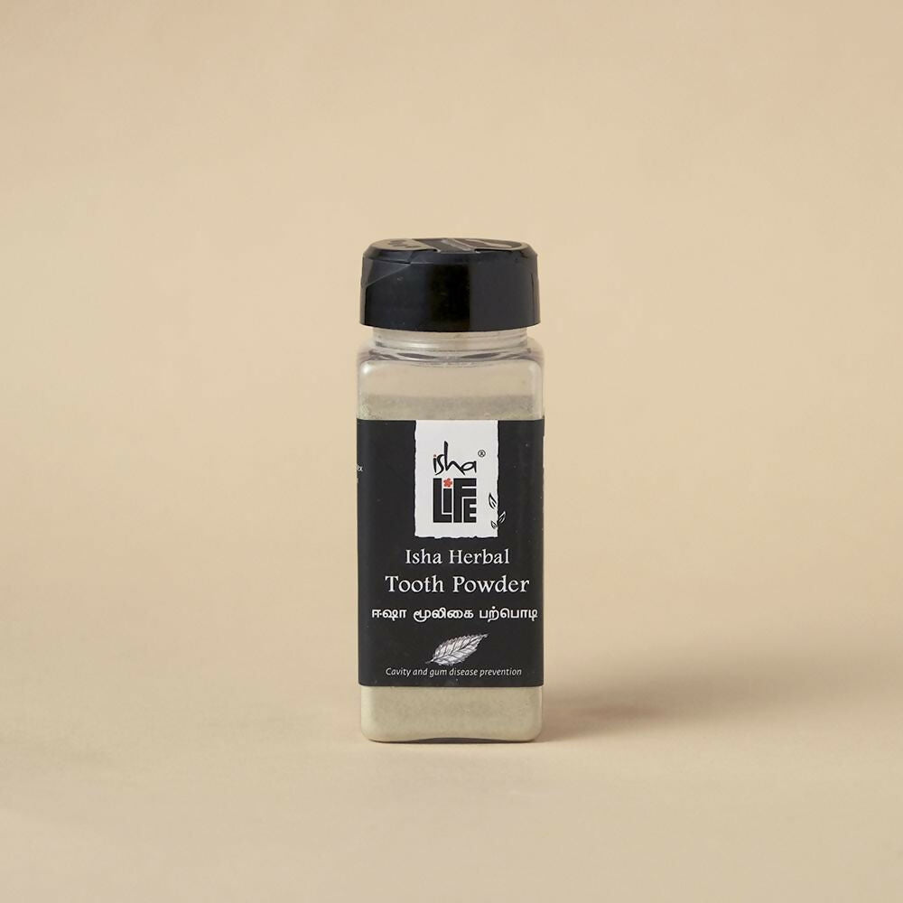 Isha Life herbal tooth powder and toothpaste combo in a natural packaging with herbal ingredients visible.