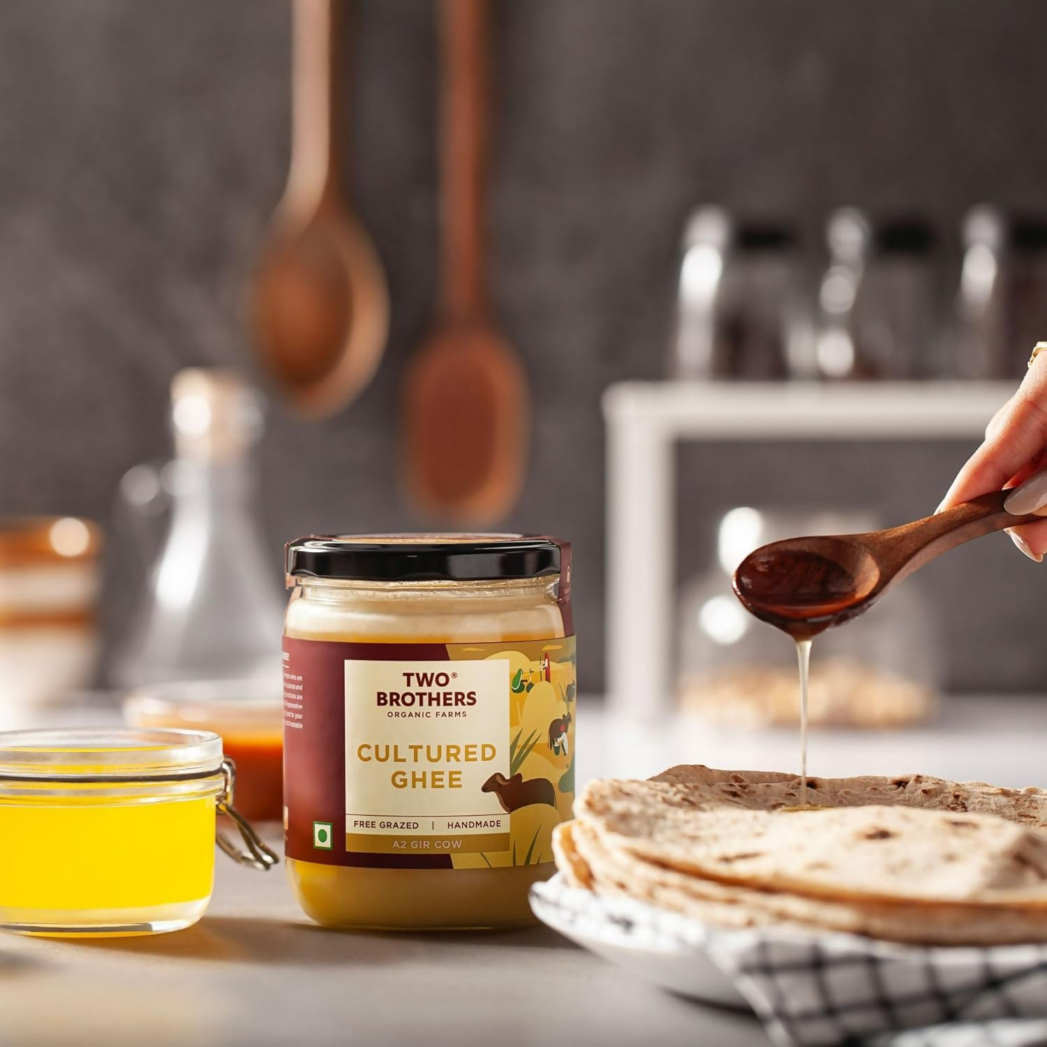 Organic cow ghee butter from Two Brothers Organic Farms, made from grass-fed Gir cows, in a glass jar with a golden hue.