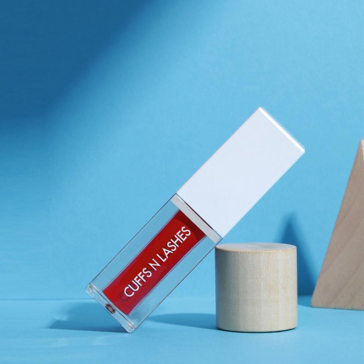CUFFS N LASHES Matte Liquid Lipstick in 10 Heyllo, featuring a sleek tube and applicator with vibrant lipstick shade visible