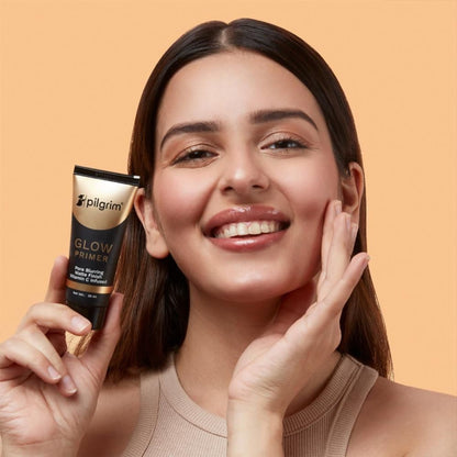 Pilgrim Instant Glow Primer with gold shimmer in a sleek tube, highlighting radiant, luminous skin for a natural glow.