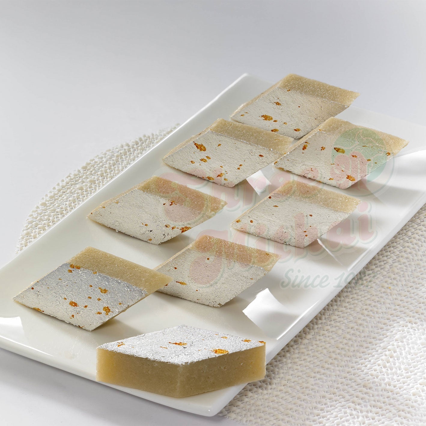 Golden Shree Mithai Badam Katli, North Indian sweet with almond slices and rich texture, display of traditional Indian dessert.
