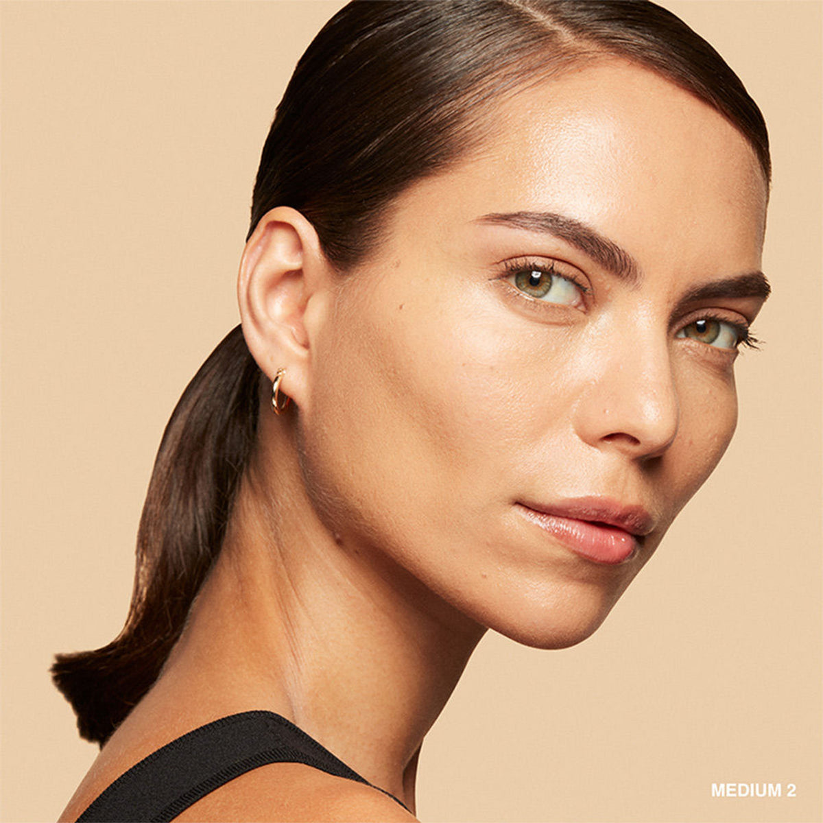 Bobbi Brown Vitamin Enriched Skin Tint in Medium 2, lightweight foundation with nourishing ingredients, visible in a sleek tube.