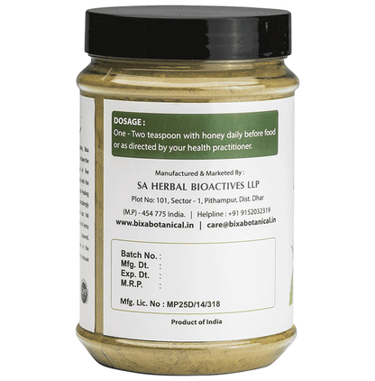 Bixa Botanical Tulsi powder in a small glass jar, showcasing the vibrant green herbal powder for Ayurvedic use.