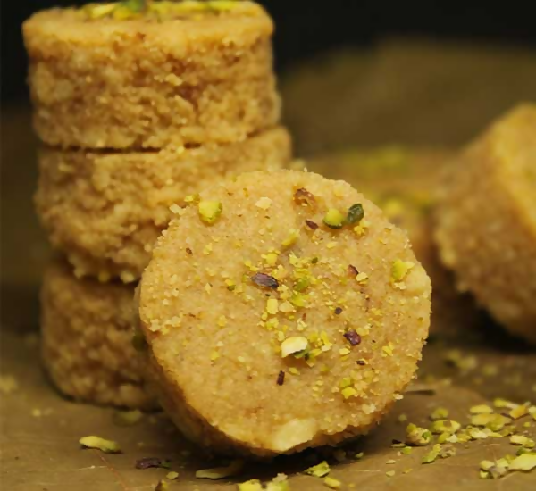 Emerald Mithai shop Doodh Peda, North Indian sweet, creamy milk fudge with a smooth texture and garnished with pistachios.