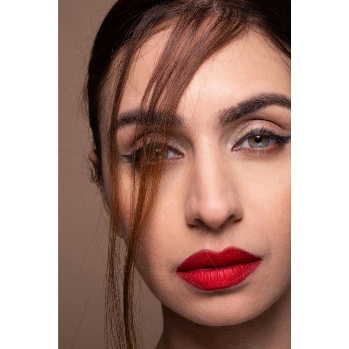 Liquid matte lipstick in shade Zarya by The Real Ritual, showing the sleek tube and applicator with a vibrant coral color.