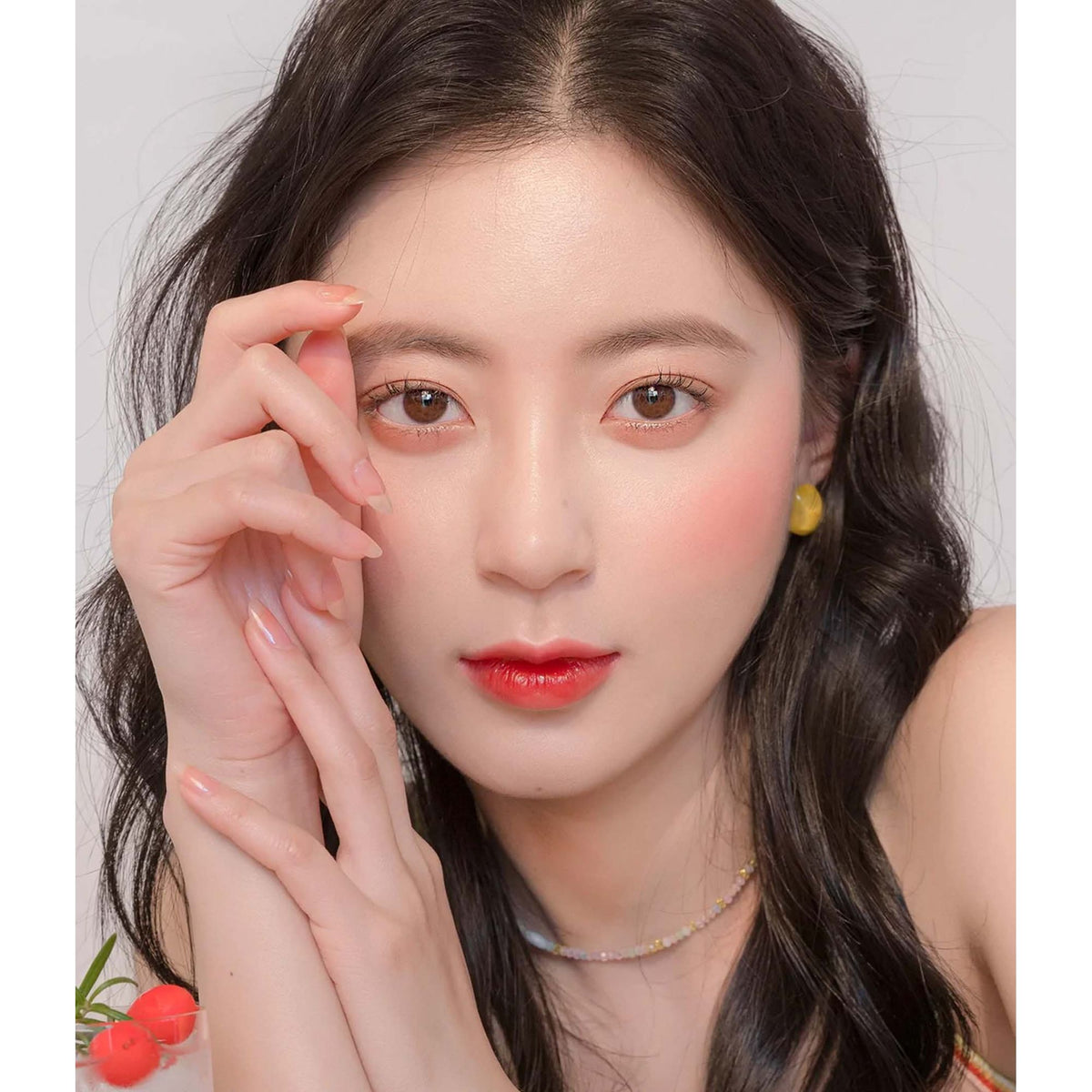 Rom&nd The Juicy Lasting Tint in 16 Corni Soda, vibrant orange-red lip tint displayed in a sleek tube with applicator wand.