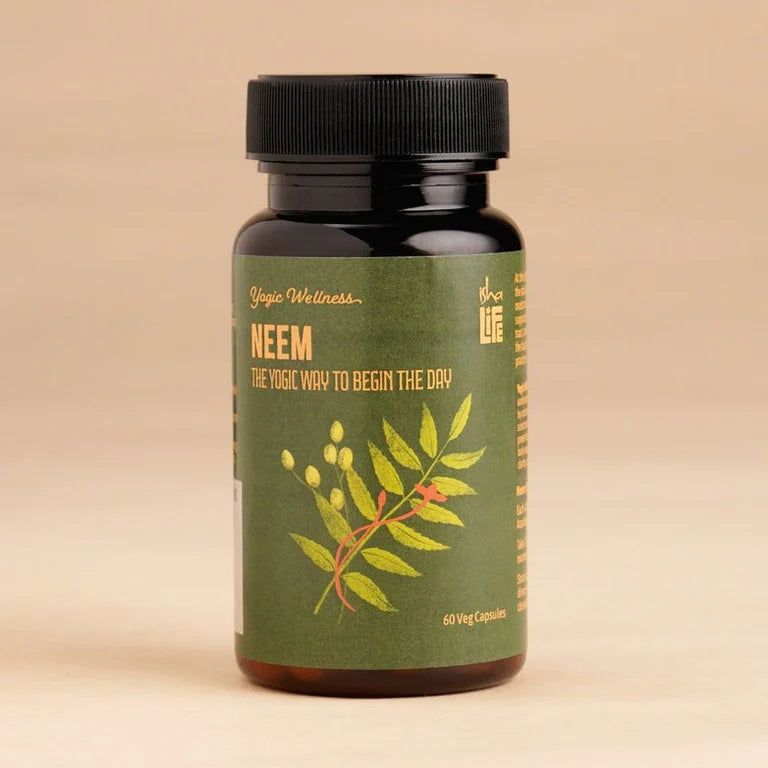 Isha Life Neem and Turmeric Ayurvedic capsules in a clear bottle, showcasing natural herbal supplement for health and wellness.